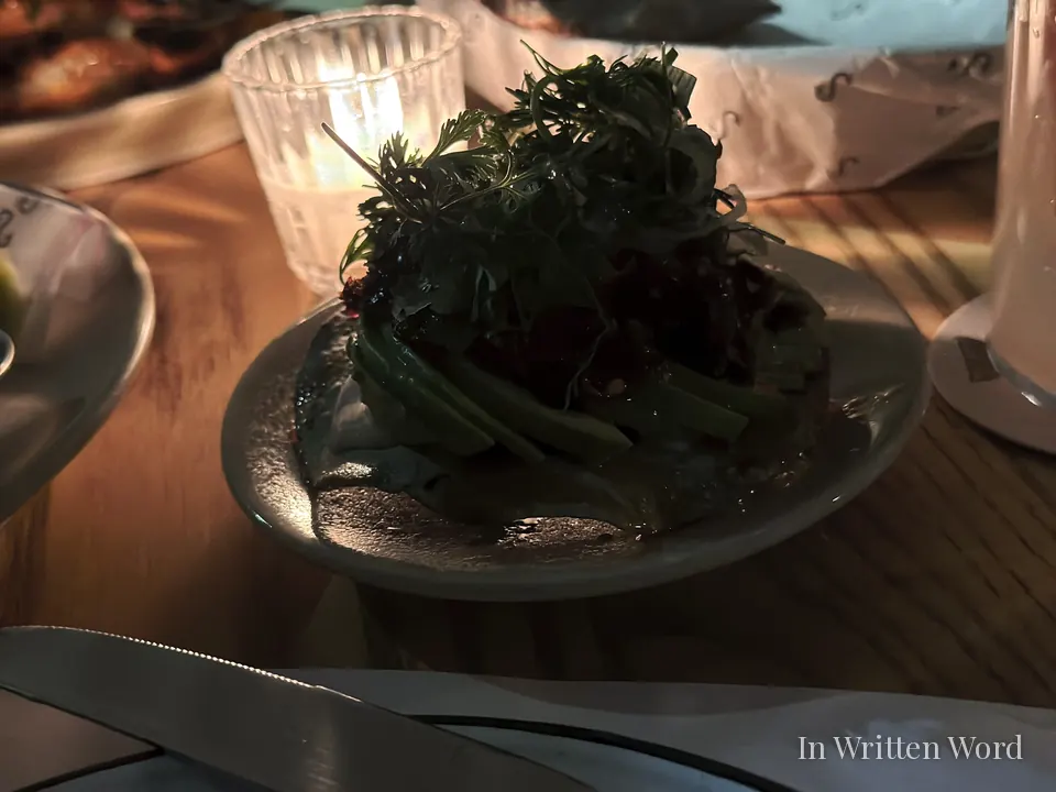 Avocado tostada at Campobaja in Mexico City topped with fresh herbs and crispy elements.
