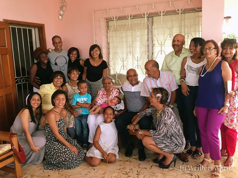 Multi-generational family gathered inside a home, representing collective care and shared responsibility.