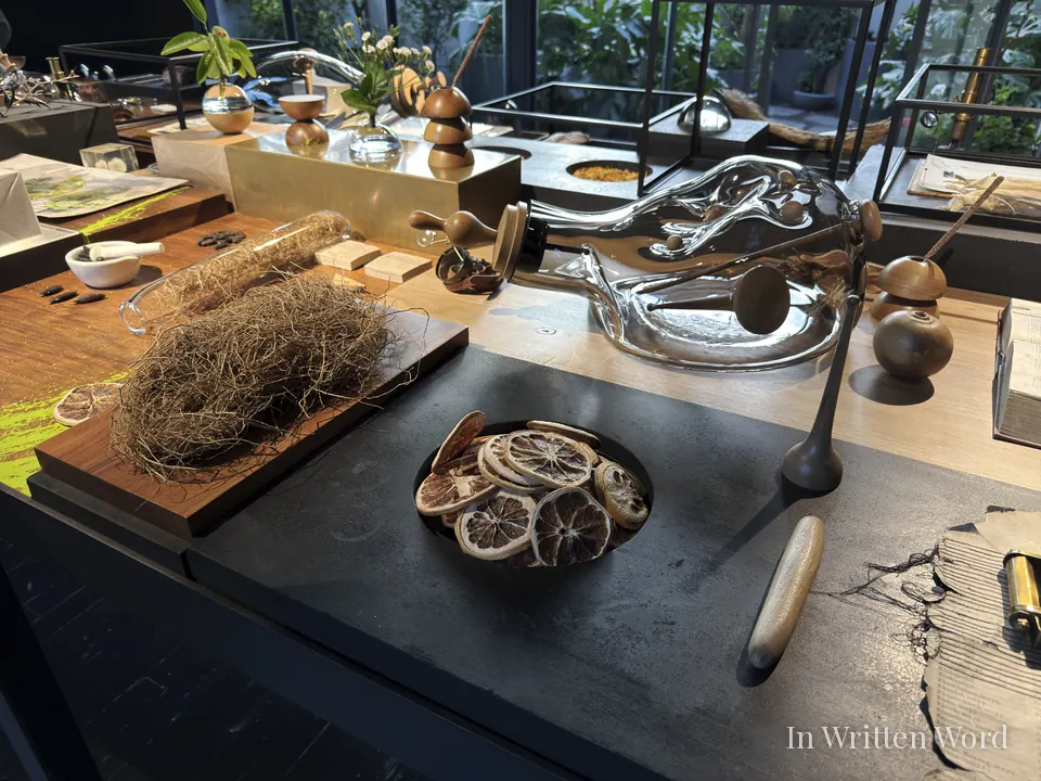 Botanical fragrance display at Xinú perfumery in Mexico City featuring glass vessels and natural ingredients.